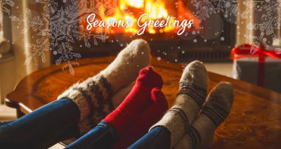 A merry Christmas from Foothealth Practice - image of peoples besocked feet by roaring fire